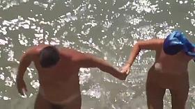Girl sucks dick her boyfriend in the surf at a public beach