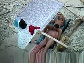 Nudist couple spied on beach.