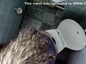 Curly girl sat down to take a piss
