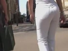 Girl in white trousers is on the street candid video 06m