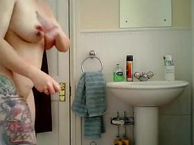 Tattooed milf spied in the bathroom