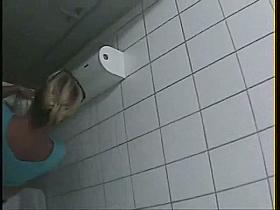 A blonde is pissing in the college toilet