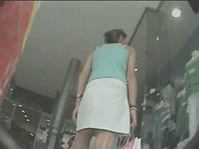 Woman in white skirt gets filmed by a nasty voyeur in the shop