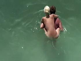 Busty blonde nudist swimming in the water