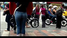 a beautiful round ass in jeans talking at a public phone