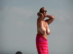 Gigantic mature tits on a beach