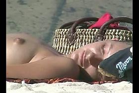 Candid beach video of a lusty girl getting her tan.