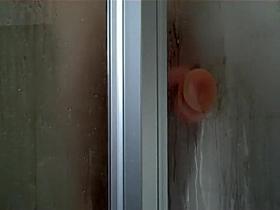 Peep her ride the sticky dildo in a shower