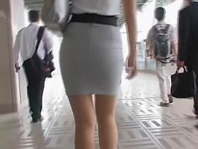 Candid upskirt of the young beauty in strict office dress