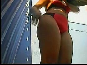 A milf is chsnging her bikini bottom in the beach dressing cabin