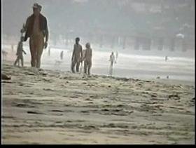 Couple play on the nude beach