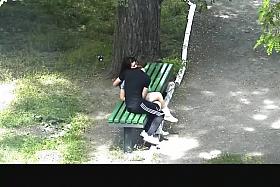 Teen couple making out in public park bench