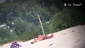Nude beach voyeur shot of two hot brunettes sunbathing
