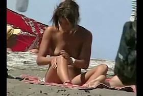 A voyeur catches a husband spanking his naked wife on the beach