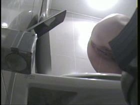 Thin woman pissing in a public toilette