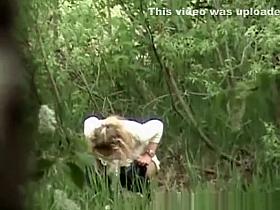 Blonde pees outdoor in nature