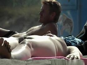 Nudist woman lying down in the sun sunbathing
