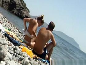 Women topless at rocky beach