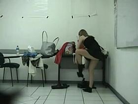A girl wearing high-heeled boots is changing her skirt in the dressing room
