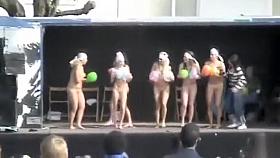 Naked ladies dance on stage with balloons
