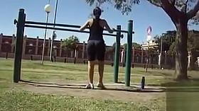 Flexible woman in spandex stretches in the park