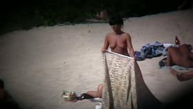Nudist beach with dressed gentlemen and topless ladies