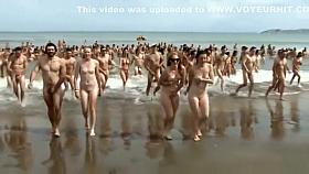 Huge group of nudists swim in the ocean
