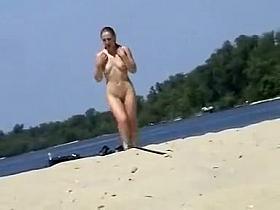 Cute topless girl smoking on a beach