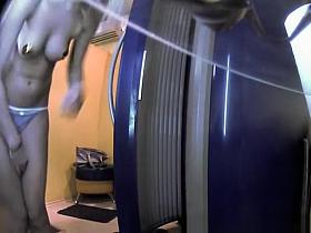 Woman undressing in tanning room