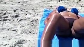 Busty woman sunbathing in bikini
