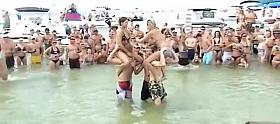 Sexy beach girls fighting each other from the shoulders of their boyfriends