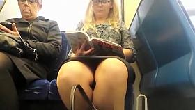 Woman reading a book in train upskirted