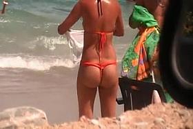 a brunette with a beautiful ass on the beach