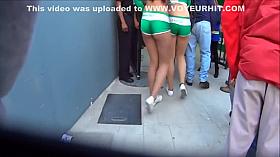 Cute model in a miniskirt mingles with people while being filmed