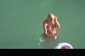 Hot blonde nudist woman swimming