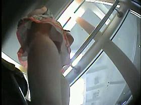 Peeking under women's skirt while taking the elevator