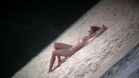 Spy cam shot of a hot nudist blond tanning on the beach