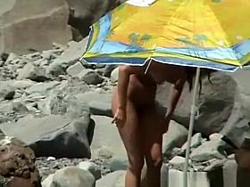 Small boobs nudist woman in the rocky beach