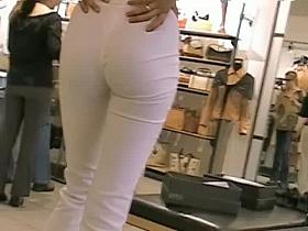 Sexy skinny brunette in white pants in candid camera