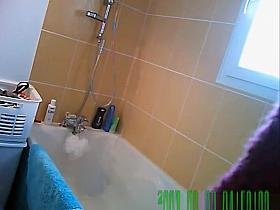 Woman washes her body in bathtub