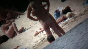 A voyeur beach video of a nude couple standing in the water