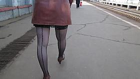 Girl in seamed stockings walking on a train station