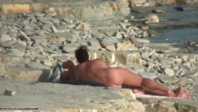 Hot cougar is lying on sand in naked beach video