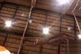 Gymnast does the uneven bars topless