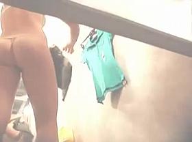 Woman is taking her clothes off in a fitting room