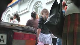 Voyeur video of a woman in high heels and white skirt