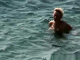 Mature nudist woman swimming