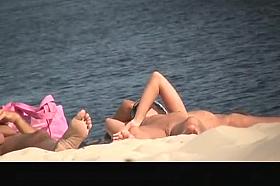 Nude woman in nudist beach sunbathing